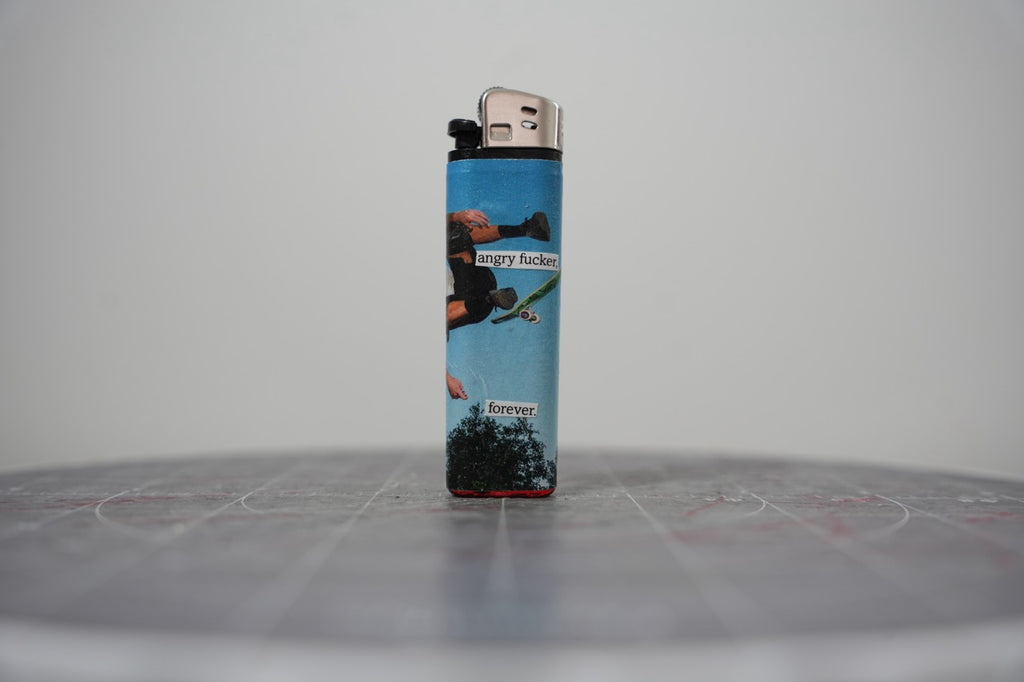 Hand-collaged lighter with sky-blue skate photography and cut-paper text reading "angry f***r." and "forever."