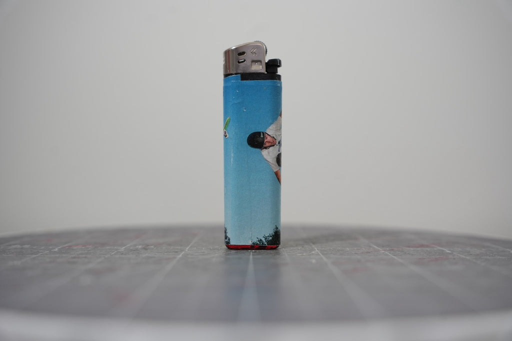 Reverse side of the sky-blue collaged lighter showing a skateboarder mid-trick