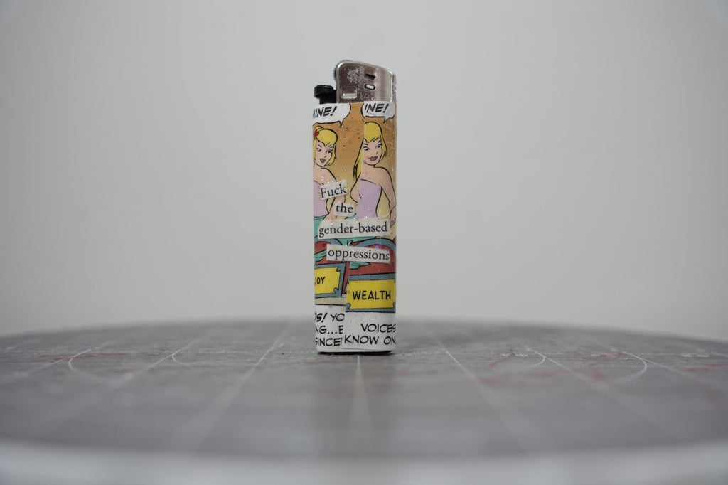 Reverse side of the Disney comic collage lighter reading "f*** the gender-based oppressions"