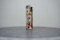 Hand-collaged lighter made from Disney comic book paper, laughing faces with cut-paper text reading "gay and transformed"