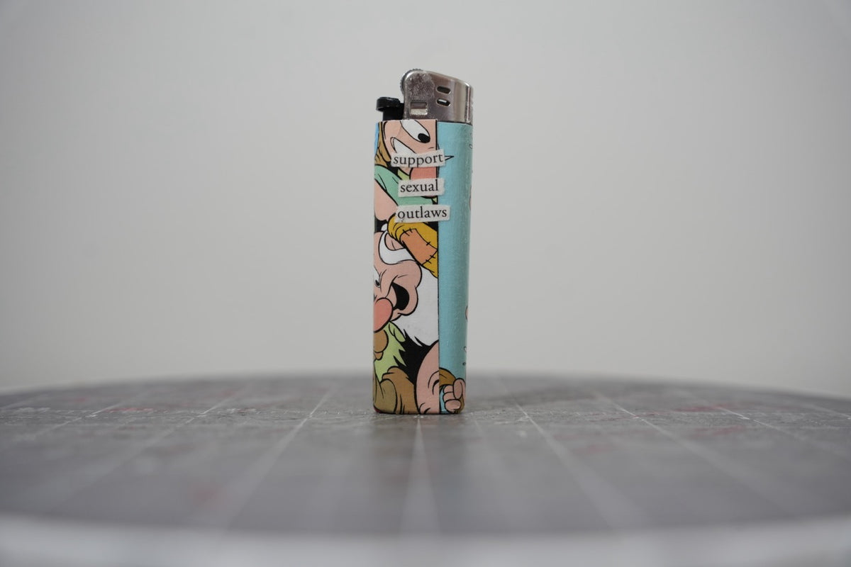Reverse side of the Disney comic collage lighter reading "support sexual outlaws"