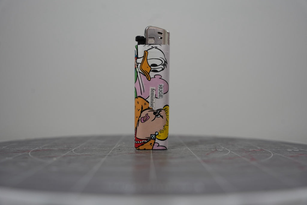 Hand-collaged lighter made from Disney comic book paper with cut-paper text reading "HUGE feminist"