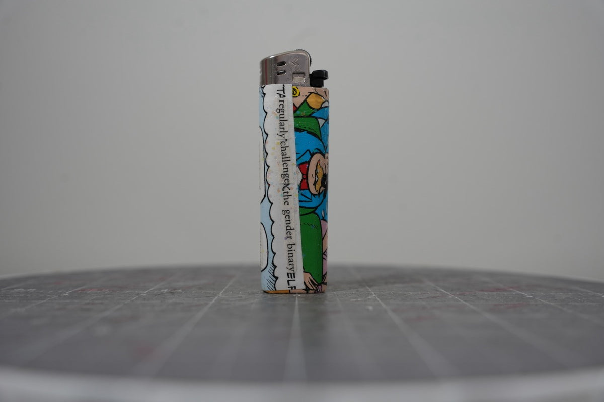 Hand-collaged lighter made from Disney comic book paper with cut-paper text reading "regularly challenge the gender binary"