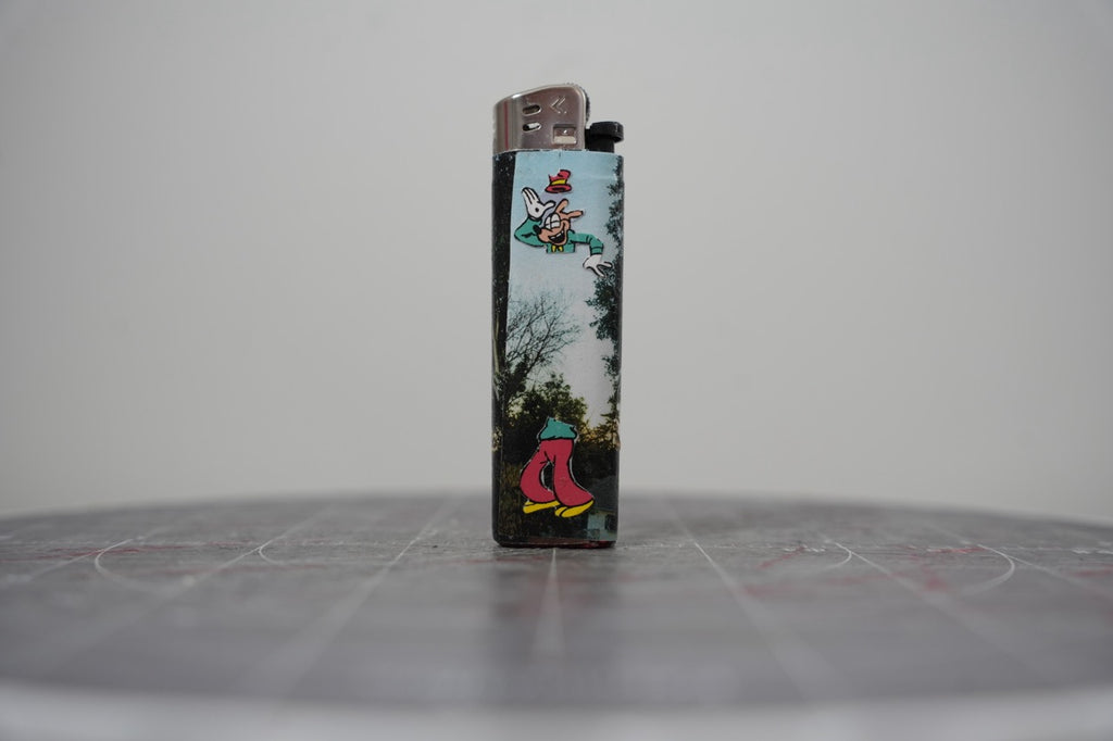 Reverse side of the same Disney comic book collage lighter, with Goofy over a photographed treeline