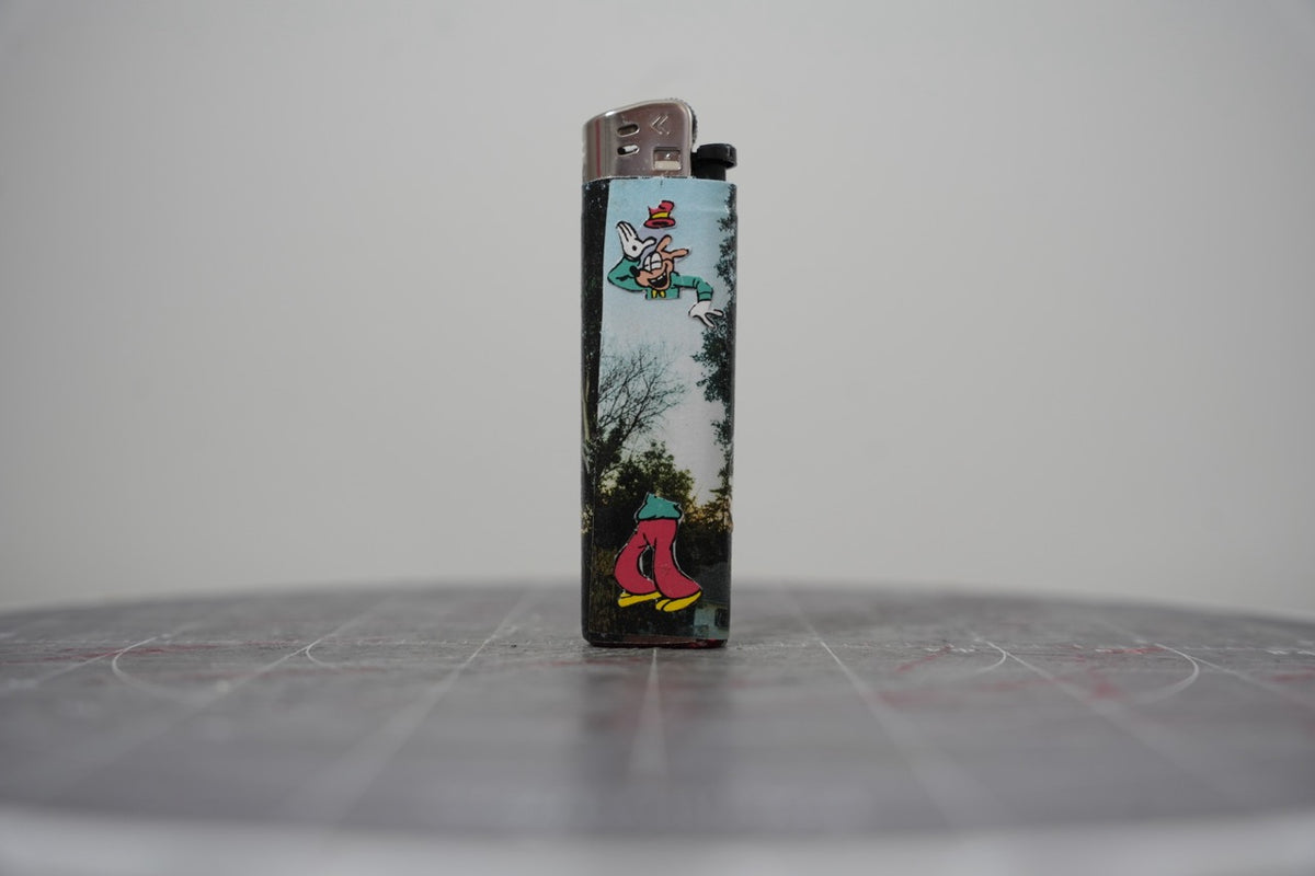 Reverse side of the same Disney comic book collage lighter, with Goofy over a photographed treeline