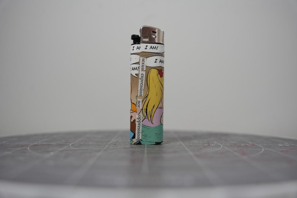 Front of a handmade collage lighter made from vintage Disney comic book paper, cut-paper text reading sexual expression not oppression