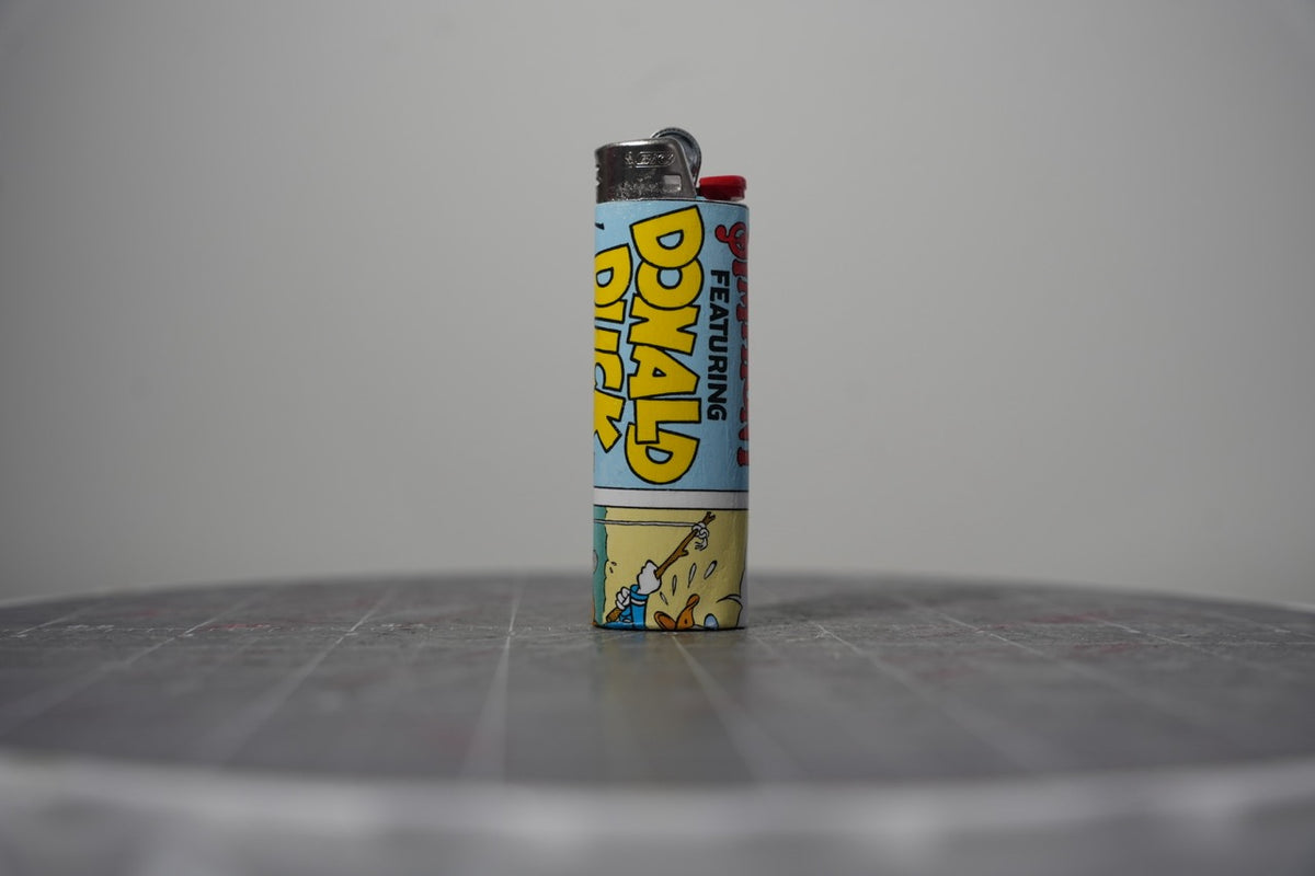 Handmade collage lighter made from vintage Disney comic book paper, featuring Donald Duck cover lettering