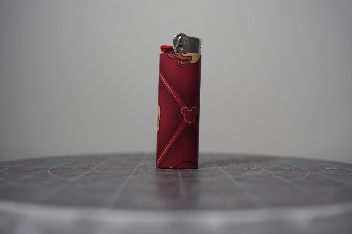 Handmade collage lighter made from vintage Disney comic book paper, dark red diamond pattern with Mickey ear icons