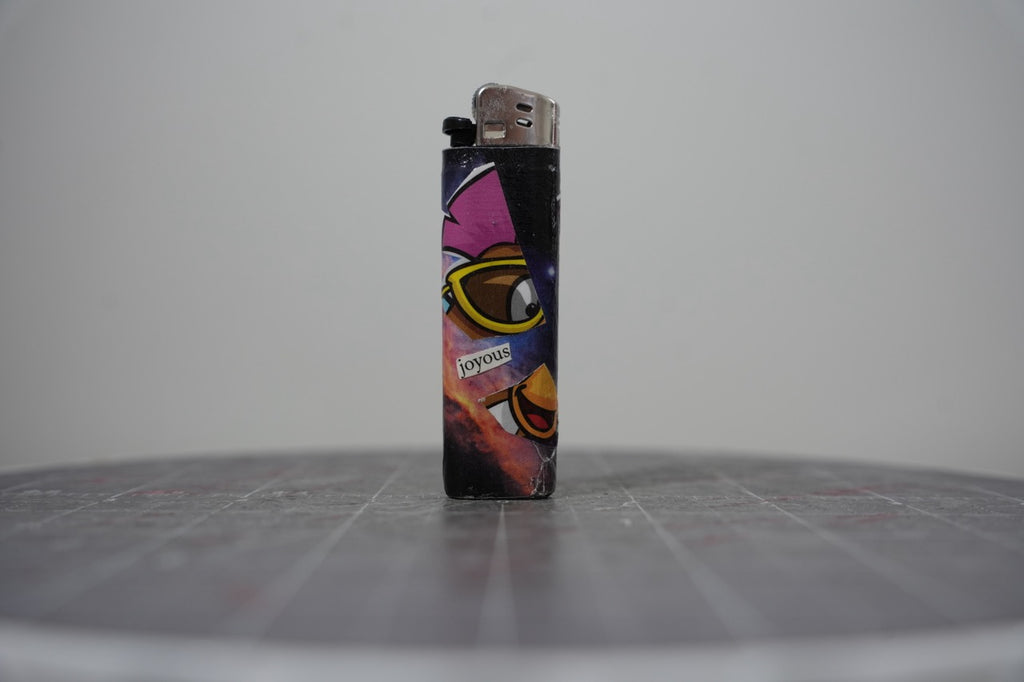 Handmade collage lighter with a cartoon bird in yellow sunglasses and the word joyous