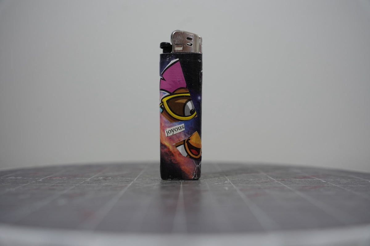Handmade collage lighter with a cartoon bird in yellow sunglasses and the word joyous