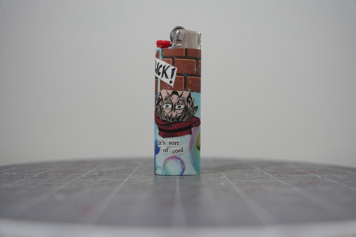 Handmade collage lighter with a brick wall, a man in glasses and a red scarf, and the words it's sort of cool