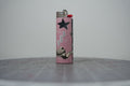 Handmade collage lighter, pink with a black star and the words sun, moon, stars