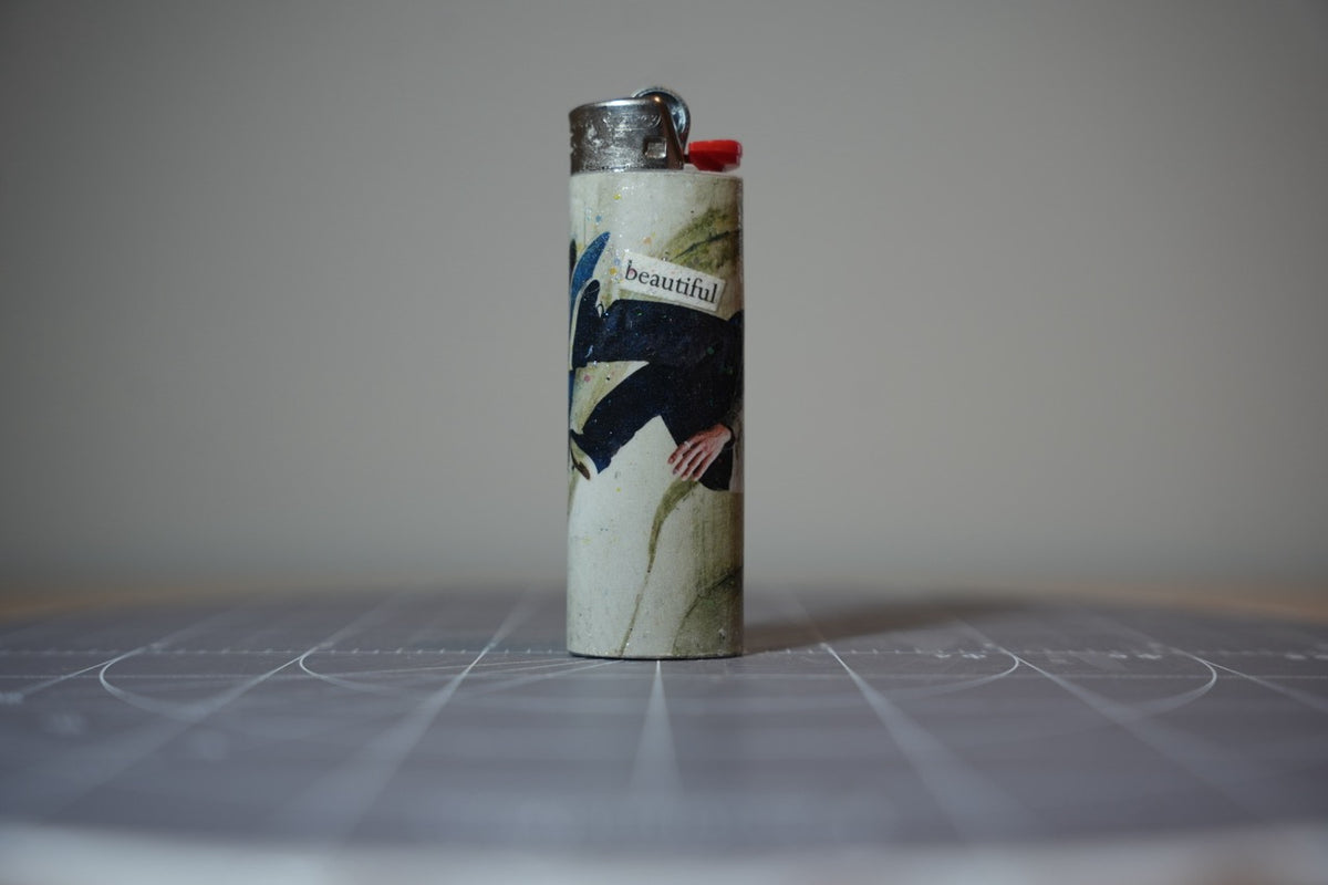 Reverse of the collage lighter showing a man in a navy coat and the word beautiful