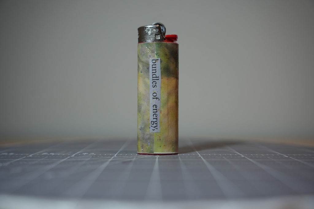 Handmade collage lighter, mottled olive and gold with the words bundles of energy