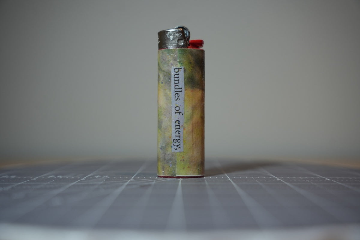 Handmade collage lighter, mottled olive and gold with the words bundles of energy